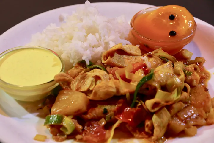 Poulet mit Nudeln und Gemüse, dazu Reis und Saucen