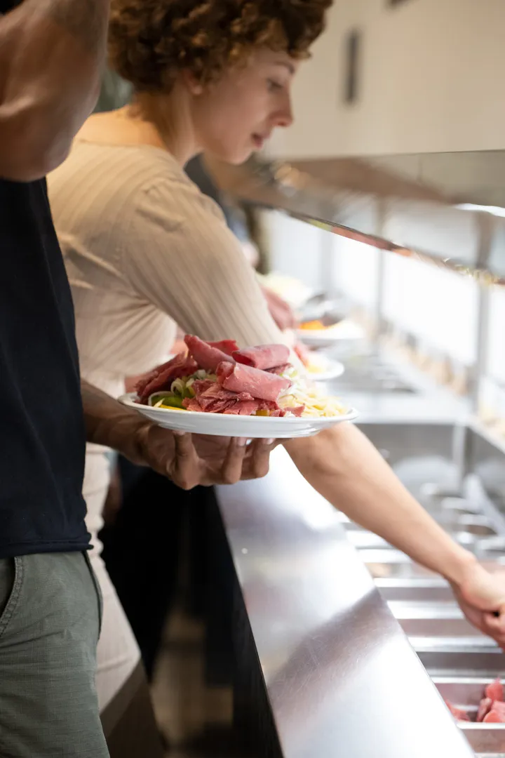Gast mit vollem Teller am Buffet