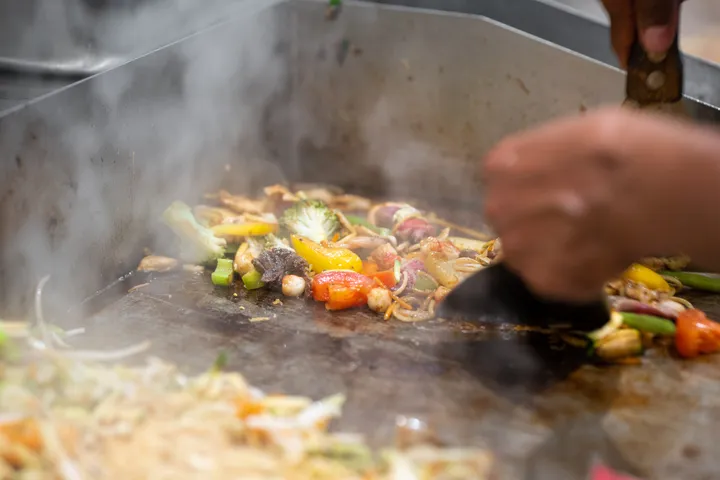 Gemüse und Fleisch zischen auf der heissen Platte